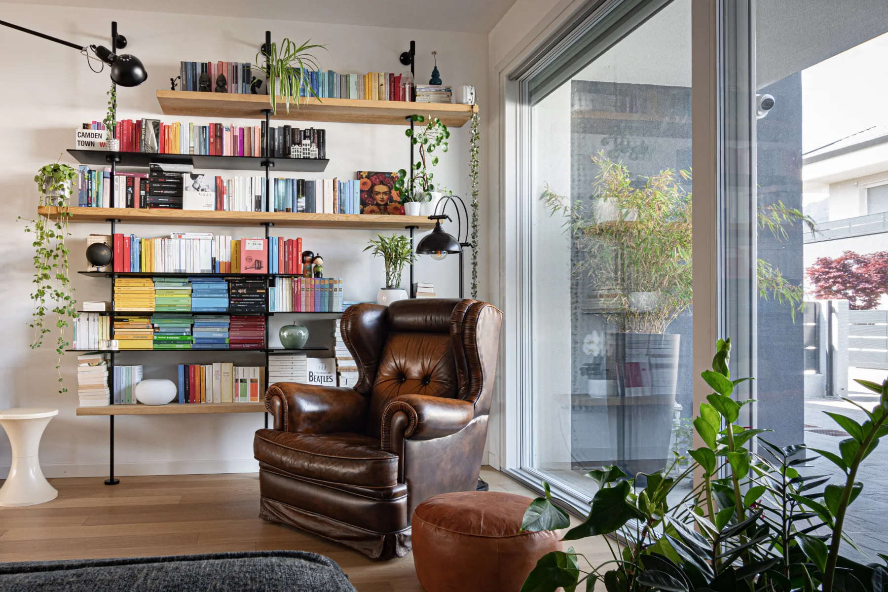 Angolo lettura con libreria stile industrial e poltrona old style in pelle